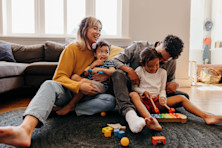 family sitting on the floor in the living room of their house