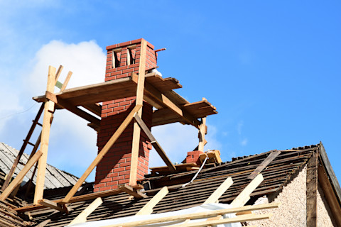 This image shows a chimney with scaffolding around it ready for maintenance or repair work to take place.