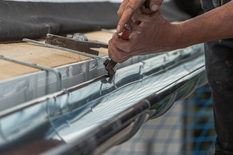 This image shows aluminium guttering being installed on a roof