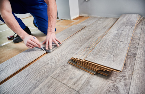 A pro is installing a new laminate wooden floor.
