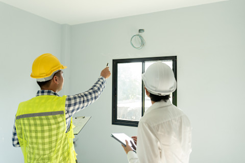 Two professionals are inspecting a newly built home.