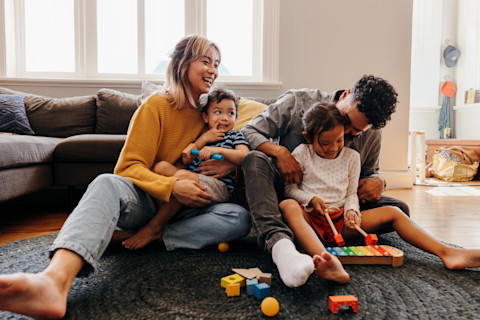 family sitting on the floor in the living room of their house