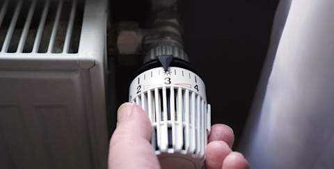 A hand turning on central heating