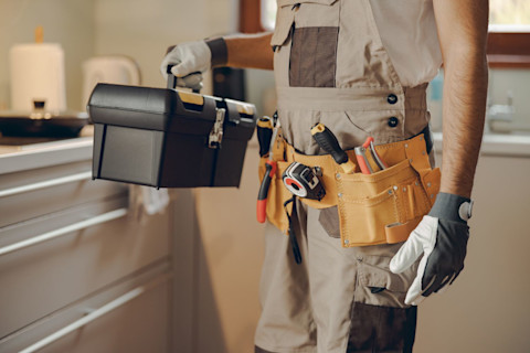 This image shows a handyman carrying some small tools around a home. 