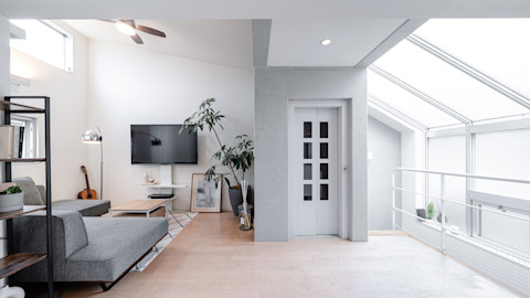 A home elevator in an open light room with grey furtniture