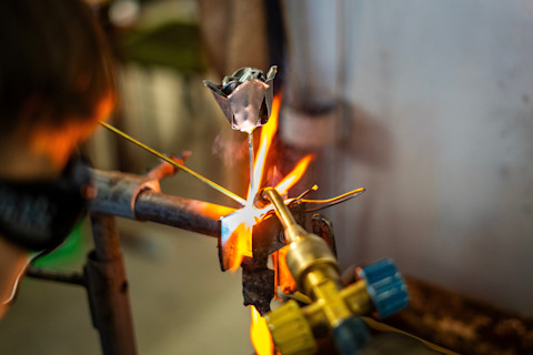 An artist is busy creating some metal work