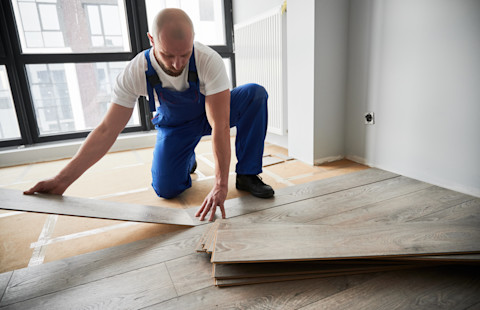 A pro is installing a new laminate wooden floor.
