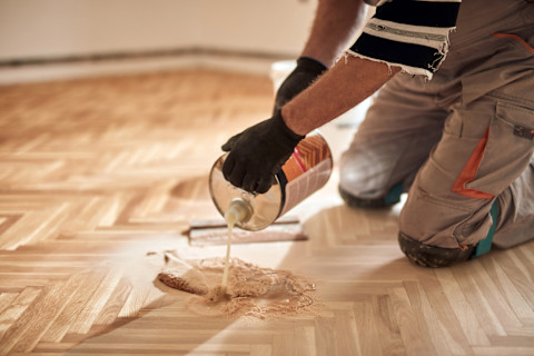 A shiny hardwood floor in a peach-coloured room.