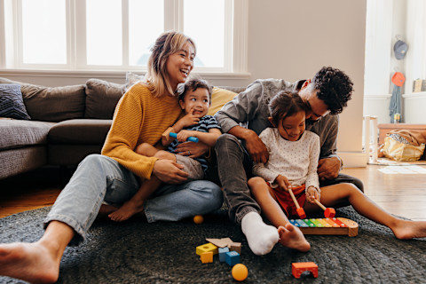 family sitting on the floor in the living room of their house