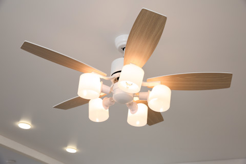 A wooden-panelled ceiling fan with lights.