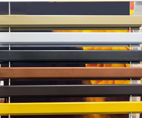 Closeup frontal shot of various samples of blinds on display in a store or trade show, all different colours.