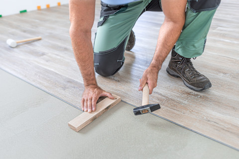 A pro is installing a new laminate wooden floor.