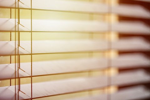 Closeup of blinds slightly closed, light-coloured wood.