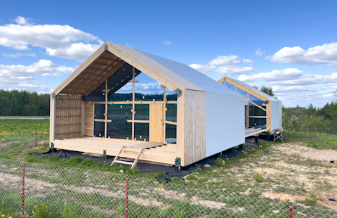 This image shows a newly constructed barndominium building. The building is made from wood and work is still in progress.
