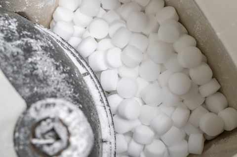 Closeup of salt pellets in a water softener unit.