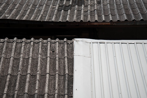 This image shows one half of a roof with shingle tiles and the other half with metal sheet.
