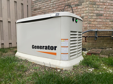 This image shows a backup generator outside on the grass of a residential property, storing enough energy to power the whole home during a power outage.