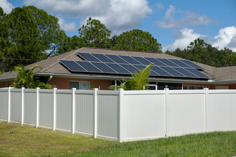 A white vinyl fence surrounds a private residential property. The fence provides privacy and a clean visual boundary.
