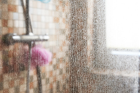 A dirty glass shower door.