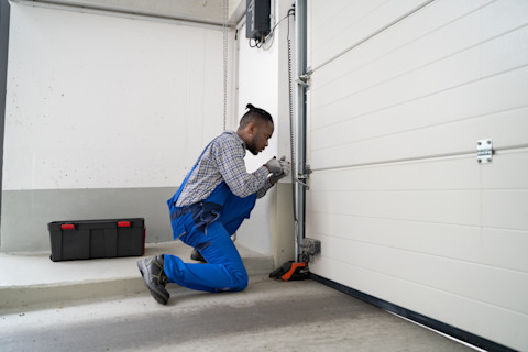 A man is busy fitting a new garage door.