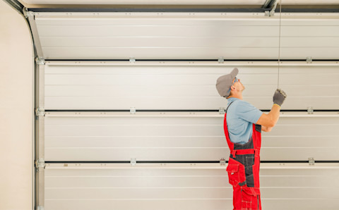 A man is checking over a new garage door.