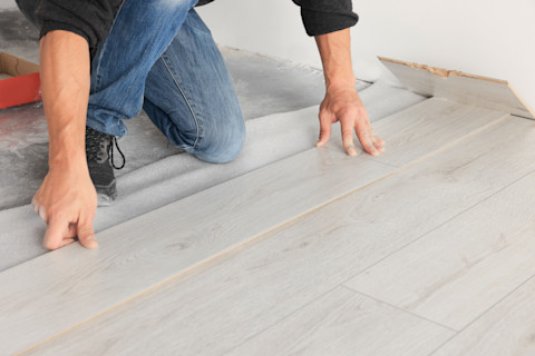 A pro is installing a new laminate wooden floor.