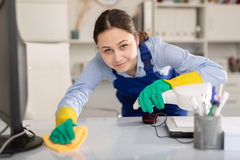 A cleaning lady is holding her supplies.