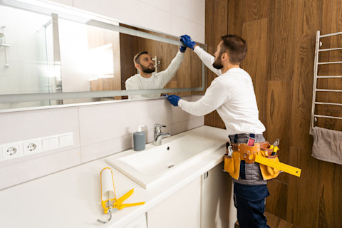 A man is installing a new bathroom in a home