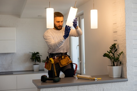 An electrician is installing a new lighting system.