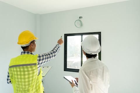 Two professionals are inspecting a newly built home.