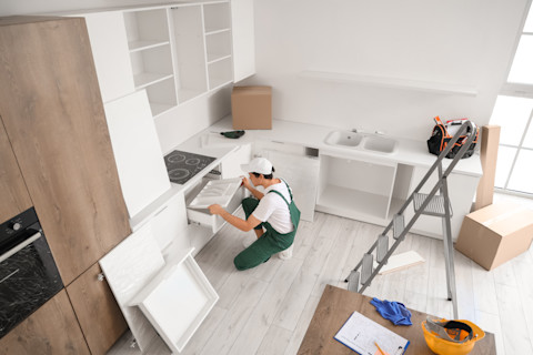 A professional is busy fitting a new kitchen.