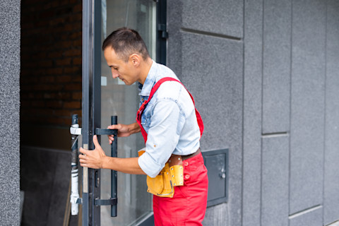 This image shows a locksmith using a key cutting machine to make a copy of a key.